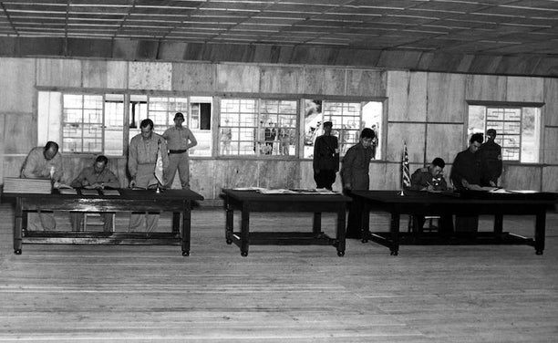 UN delegate Lieut. Gen. William K. Harrison, Jr. (left) and Korean People’s Army and Chinese People’s Volunteers delegate Gen. Nam Il (right) sign the Korean War Armistice Agreement. July 27, 1953.