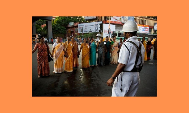 Image: Wikimedia Commons; Policeman facing women in a protest march, Kolkata India