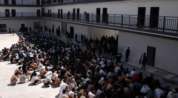 A large group of migrant workers wait to be repatriated in the courtyard of a "scam compound" in Myanmar after a police raid.