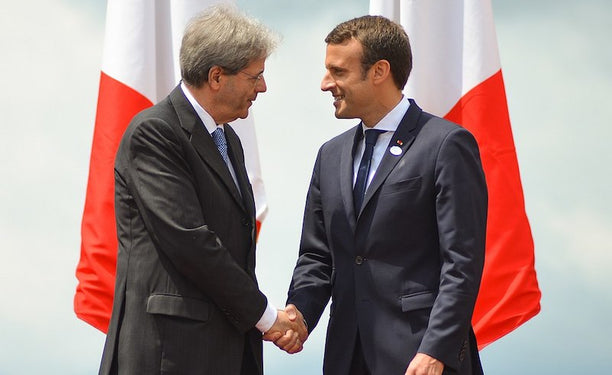 Italian Prime Minister Paolo Gentiloni shakes hands with Emmanuel Macron at the G7 summit, May 2017. via Wikimedia Commons.