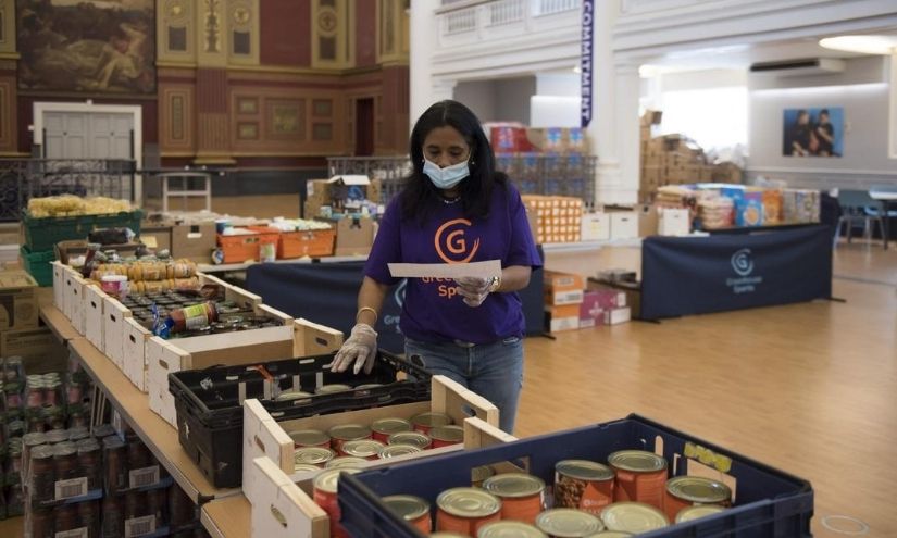 A woman wearing a surgical mask and gloves takes an inventory in a foodbank (Image: CharityToday)