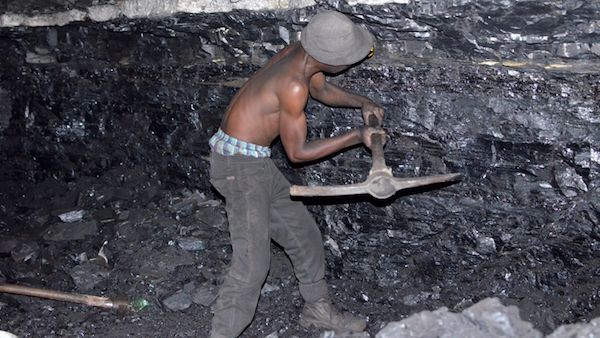 A small-scale miner illegally digs coal from an abandoned, former Anker Coal operation just outside Ermelo, Mpumalanga. Image by Mark Olalde. South Africa, 2017.